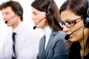 Customer service team working in headsets, woman in front.